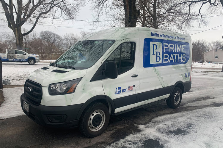 Team Member posing with Prime Baths van